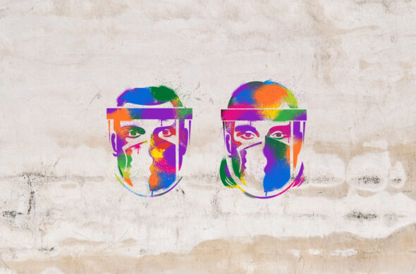 Masked faces are stenciled onto a wall in a rainbow of colors