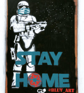 A Star Wars stormtrooper wearing a medical mask with the words STAY AT HOME underneath. (The "O' is the logo the Empire from Star Wars.)
