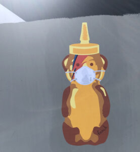 A painting of a honey bear container with a Ziggy Stardust colored lightning bolt on its face wearing a medical mask