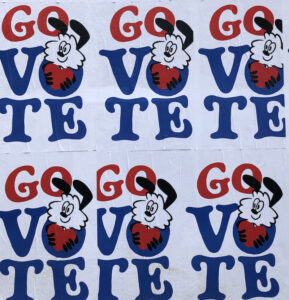 A cartoony animal holds a heart on multiple posters that read "GO VOTE"
