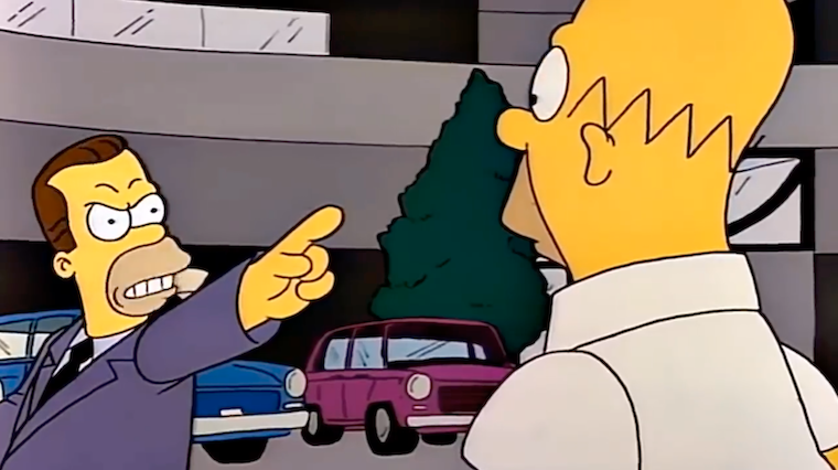 Herb Powell points at Homer Simpson in a car showroom