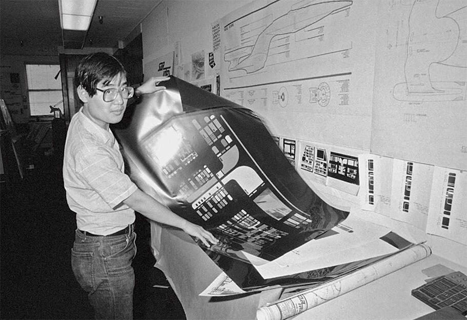 Designer Michael Okuda displays an okudagram on a long sheet for Star Trek