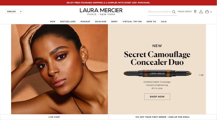 A screenshot from the Laura Mercier site, with a low-contrast background and photograph of a model accompanied by a serif font headline
