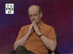 Colin Mochrie of Whose Line Is It Anyway changes from a pondering expression to double pointing at the camera